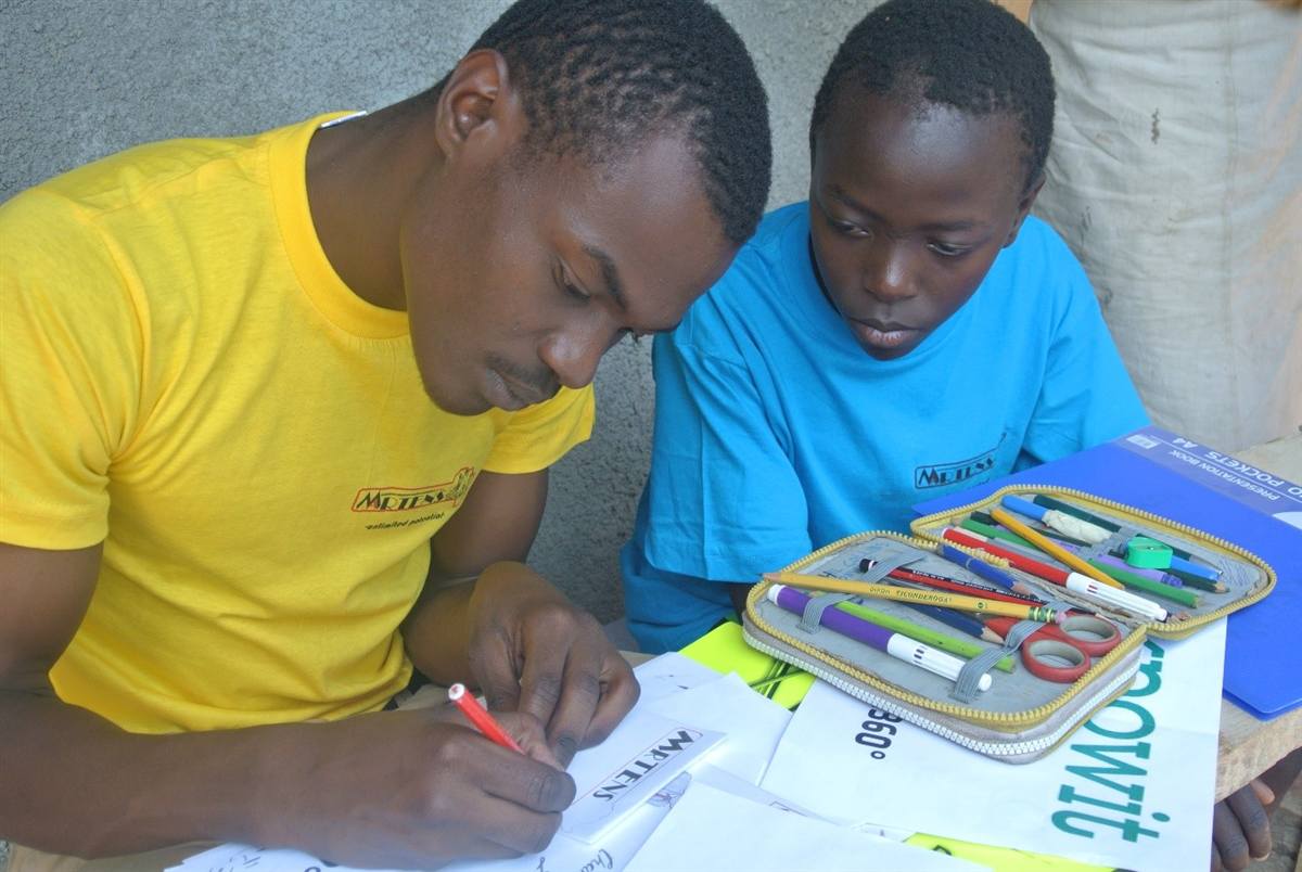 A Martens Africa volunteer helping a child with an art project